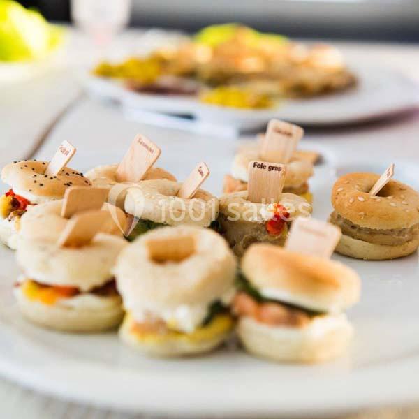 Assortiment de mini-burgers et bouchées salées présentés sur une assiette blanche.
