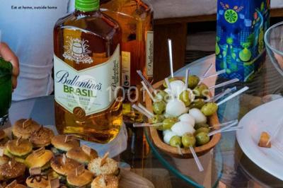 Salle de réception décorée avec des tables alignées, nappes blanches, chaises pliantes et ornements suspendus.