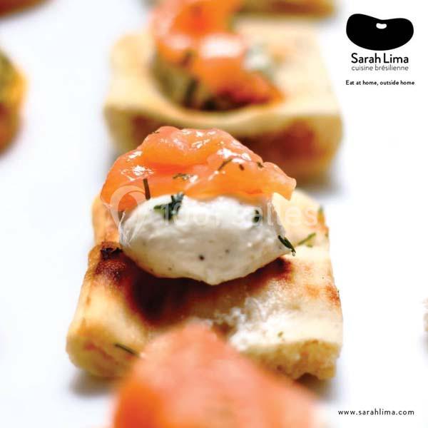 Bouchées de pain grillé garnies de fromage frais, saumon fumé et herbes, présentées en gros plan.