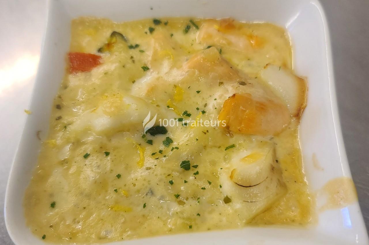 Plat de fruits de mer en sauce crémeuse, servi dans un bol blanc, garni de persil haché.