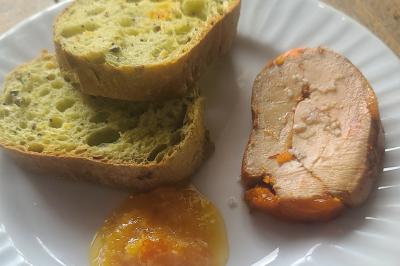 Table avec une pièce montée, des bouteilles de champagne, une pyramide de flûtes et une pile d'assiettes blanches.