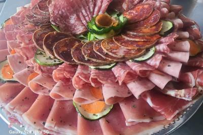 Table avec une pièce montée, des bouteilles de champagne, une pyramide de flûtes et une pile d'assiettes blanches.