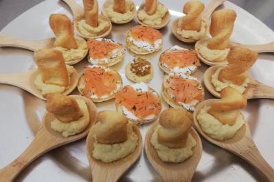 Table avec une pièce montée, des bouteilles de champagne, une pyramide de flûtes et une pile d'assiettes blanches.