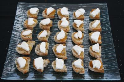 Table avec une pièce montée, des bouteilles de champagne, une pyramide de flûtes et une pile d'assiettes blanches.