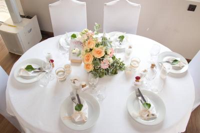 Table avec une pièce montée, des bouteilles de champagne, une pyramide de flûtes et une pile d'assiettes blanches.