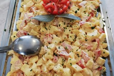 Table avec une pièce montée, des bouteilles de champagne, une pyramide de flûtes et une pile d'assiettes blanches.