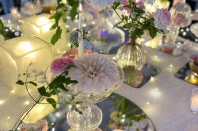 Un couple de mariés danse sous des lumières suspendues, entouré d'invités célébrant avec des serviettes levées.