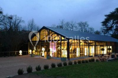 Un couple de mariés danse sous des lumières suspendues, entouré d'invités célébrant avec des serviettes levées.