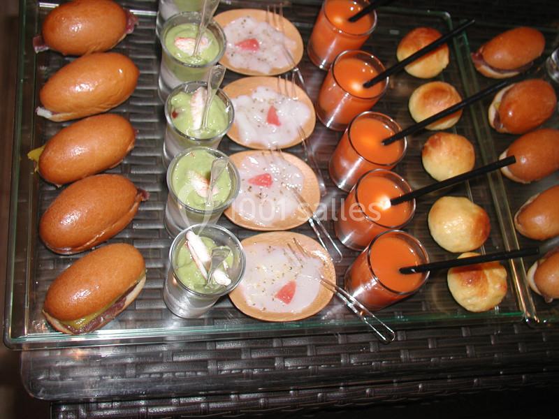 Plateau de bouchées apéritives variées comprenant mini-sandwichs, verrines, cuillères garnies et petits pains.