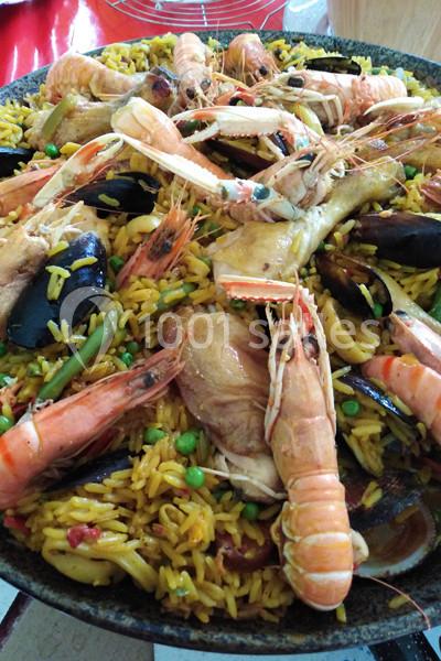 Plat de paella aux fruits de mer avec crevettes, moules, langoustines, légumes et riz safrané.