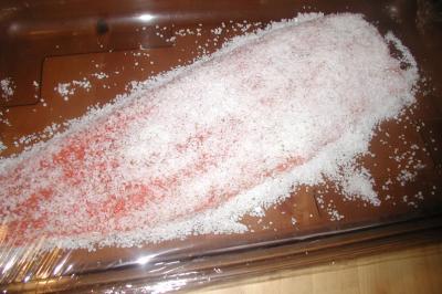 Gâteau décoré de tranches de fraises disposées en cercle avec une fraise entière et une feuille de menthe au centre.