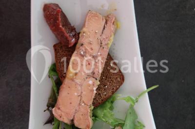 Gâteau décoré de tranches de fraises disposées en cercle avec une fraise entière et une feuille de menthe au centre.