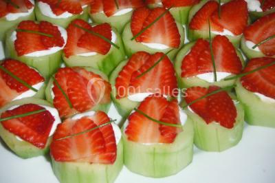 Gâteau décoré de tranches de fraises disposées en cercle avec une fraise entière et une feuille de menthe au centre.