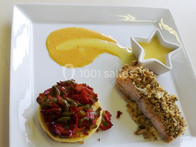 Assiette gastronomique avec saumon en croûte, légumes colorés, purée en cercle et sauce jaune en présentation soignée.
