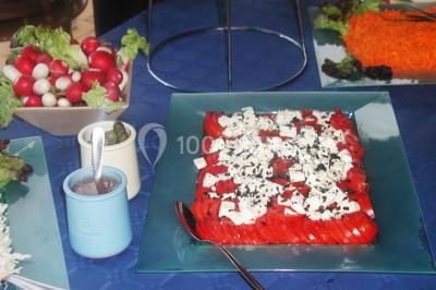 Gâteau décoré de tranches de fraises disposées en cercle avec une fraise entière et une feuille de menthe au centre.