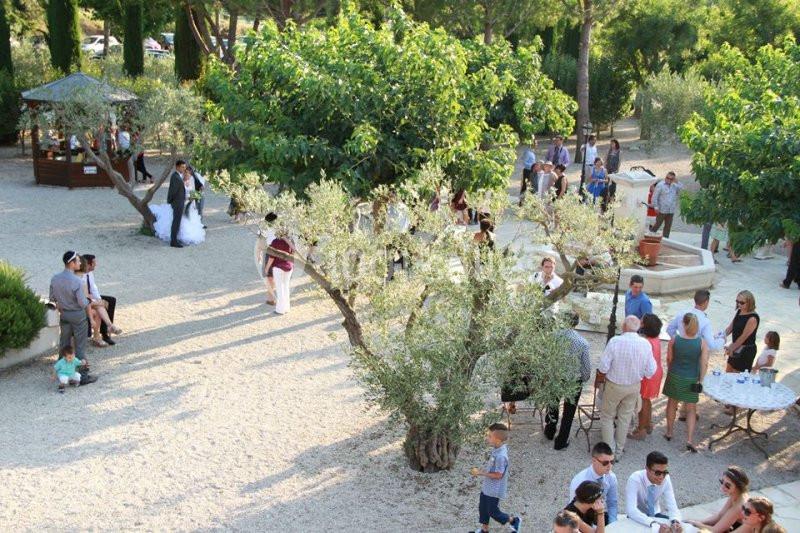 Groupe de personnes réunies en extérieur dans un jardin arboré avec une fontaine au centre.