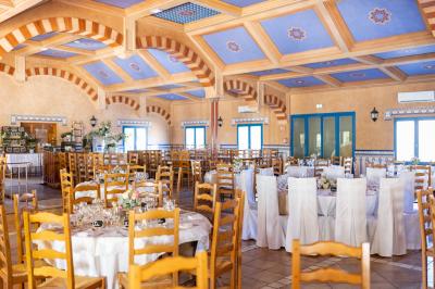 Une cavalière en tenue traditionnelle guide un cheval blanc dans une arène devant un public attentif.
