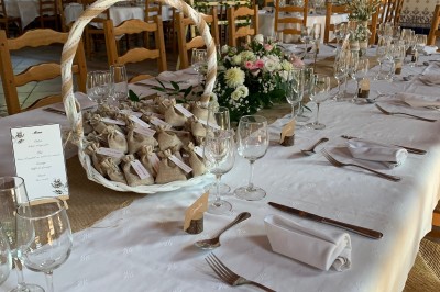 Une cavalière en tenue traditionnelle guide un cheval blanc dans une arène devant un public attentif.