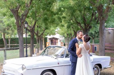 Une cavalière en tenue traditionnelle guide un cheval blanc dans une arène devant un public attentif.