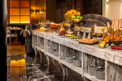 Salle de soins avec table de massage, produits de beauté, serviettes pliées, plantes et éclairage tamisé.