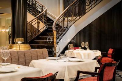 Salle de soins avec table de massage, produits de beauté, serviettes pliées, plantes et éclairage tamisé.