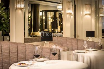 Salle de soins avec table de massage, produits de beauté, serviettes pliées, plantes et éclairage tamisé.