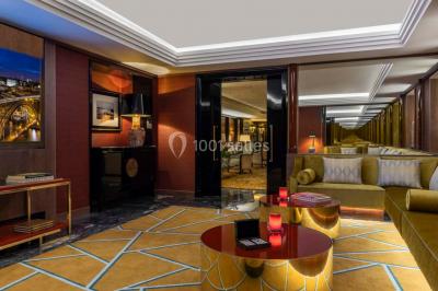 Salle de soins avec table de massage, produits de beauté, serviettes pliées, plantes et éclairage tamisé.