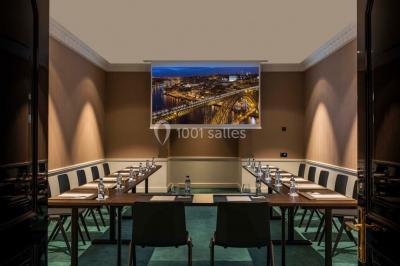 Salle de soins avec table de massage, produits de beauté, serviettes pliées, plantes et éclairage tamisé.