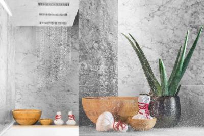 Salle de soins avec table de massage, produits de beauté, serviettes pliées, plantes et éclairage tamisé.