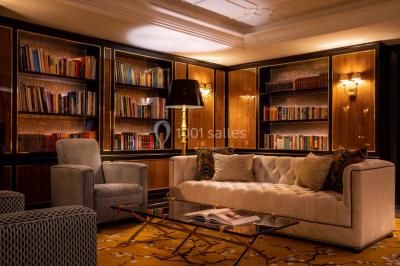 Salle de soins avec table de massage, produits de beauté, serviettes pliées, plantes et éclairage tamisé.