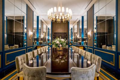 Salle de soins avec table de massage, produits de beauté, serviettes pliées, plantes et éclairage tamisé.