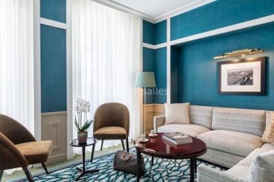 Salle de soins avec table de massage, produits de beauté, serviettes pliées, plantes et éclairage tamisé.