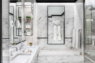 Salle de soins avec table de massage, produits de beauté, serviettes pliées, plantes et éclairage tamisé.