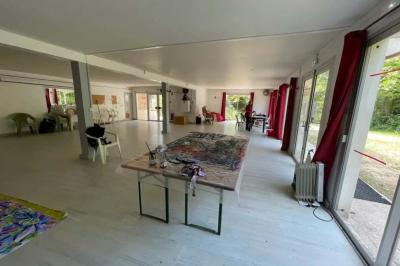 Jardin verdoyant avec des palmiers, des pins et des buissons sous un ciel ensoleillé, décoré de dessins orange.