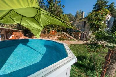 Jardin verdoyant avec des palmiers, des pins et des buissons sous un ciel ensoleillé, décoré de dessins orange.