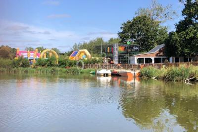 Chambre avec un lit double, draps gris, deux tables de chevet en bois, mur gris et sol en parquet clair.