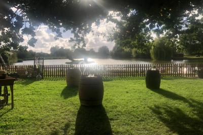 Chambre avec un lit double, draps gris, deux tables de chevet en bois, mur gris et sol en parquet clair.