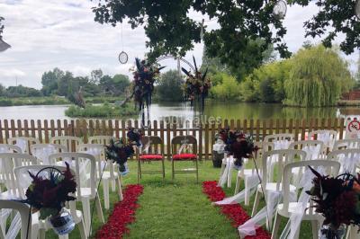 Chambre avec un lit double, draps gris, deux tables de chevet en bois, mur gris et sol en parquet clair.