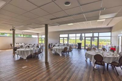 Salle intérieure avec simulateurs de golf, zone d'entraînement au putting et équipements sportifs modernes.