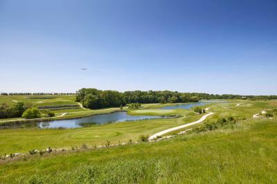 Salle intérieure avec simulateurs de golf, zone d'entraînement au putting et équipements sportifs modernes.