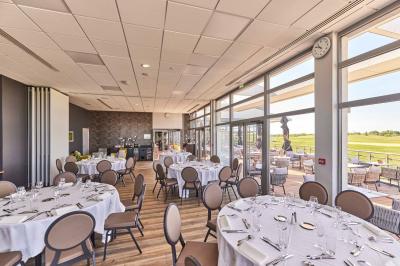 Salle intérieure avec simulateurs de golf, zone d'entraînement au putting et équipements sportifs modernes.