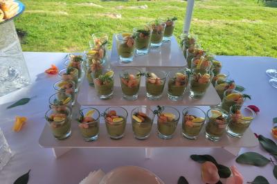 Salle de réception décorée avec des tables dressées, des chaises ornées de nœuds roses et des bouquets de fleurs.