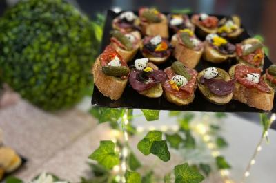 Assiettes de pastillas saupoudrées de sucre glace, accompagnées de salade verte, légumes frais et fleurs comestibles.