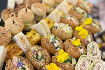 Assiettes de pastillas saupoudrées de sucre glace, accompagnées de salade verte, légumes frais et fleurs comestibles.