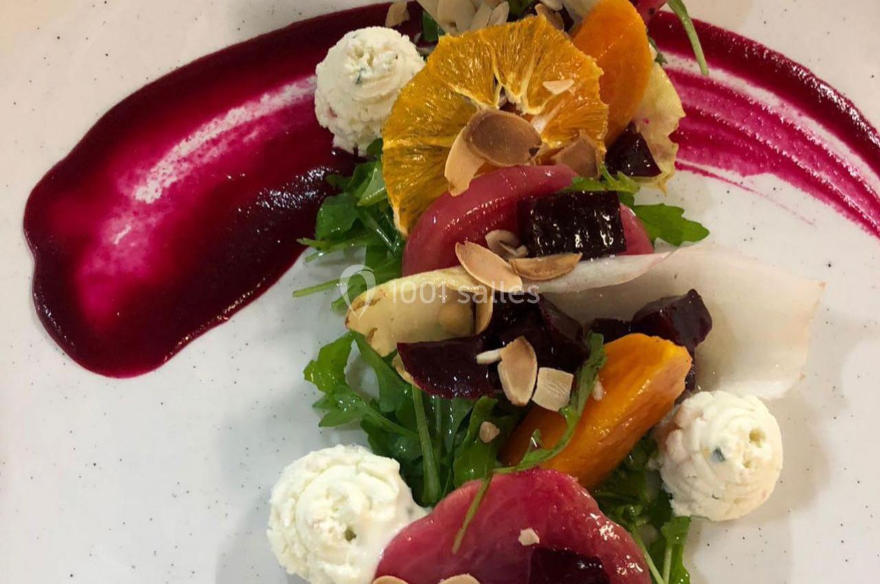 Salade colorée avec betteraves, oranges, fromage frais, amandes effilées et sauce rouge dressée en courbe.