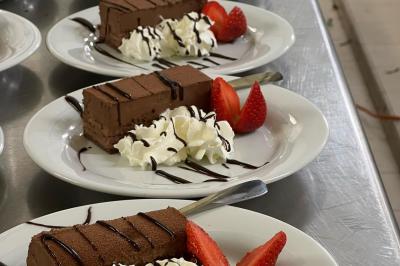 Assiettes de pastillas saupoudrées de sucre glace, accompagnées de salade verte, légumes frais et fleurs comestibles.