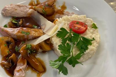 Assiettes de pastillas saupoudrées de sucre glace, accompagnées de salade verte, légumes frais et fleurs comestibles.