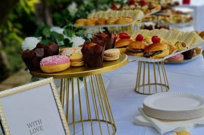 Assiettes de pastillas saupoudrées de sucre glace, accompagnées de salade verte, légumes frais et fleurs comestibles.