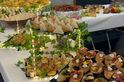 Assiettes de pastillas saupoudrées de sucre glace, accompagnées de salade verte, légumes frais et fleurs comestibles.