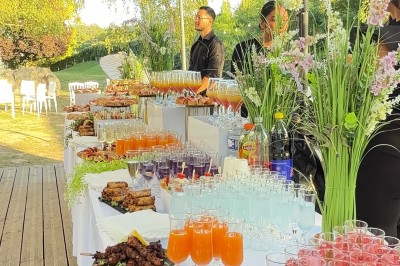 Miniature Traiteur Beauchamp (Val-d'Oise) - L'instant Gourmand #14 Buffet en extérieur avec brochettes, cocktails colorés, viennoiseries et décor floral sur une table blanche.